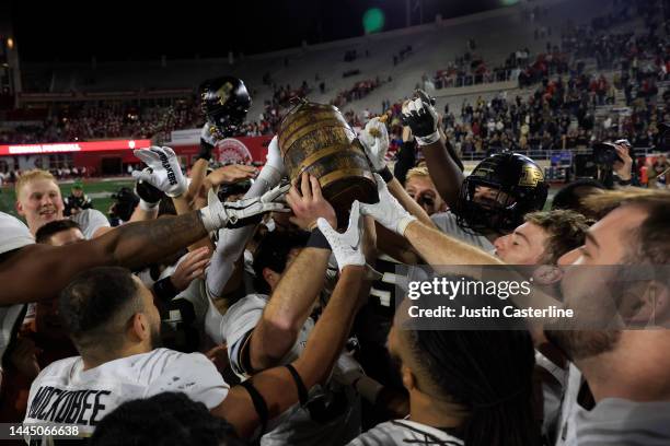 The Purdue Boilermakers hold up the Old Oaken Bucket after a win over the Indiana Hoosiers at Memorial Stadium on November 26, 2022 in Bloomington,...