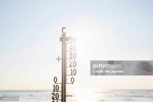 thermometer against sea, sky and sun - meteorology thermometers stock pictures, royalty-free photos & images