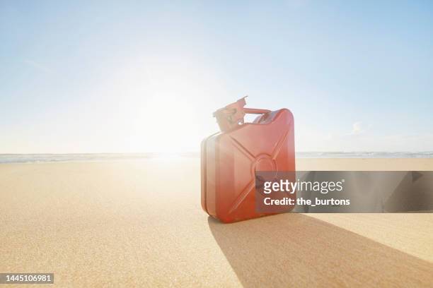 red spare canister at beach against sea and sun - lata de óleo imagens e fotografias de stock