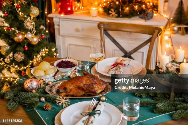 christmas dinner roast goose turkey with orange slices, red cabbage and potato dumplings in cozy home - christmas table turkey stock pictures, royalty-free photos & images