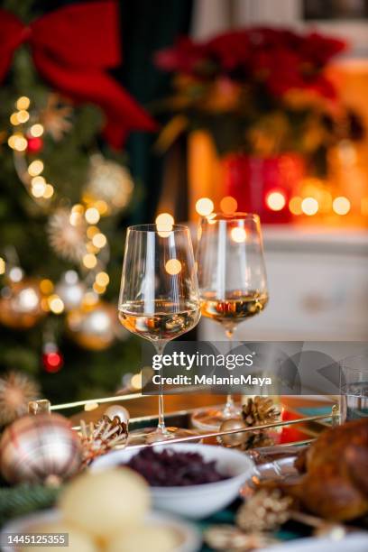 mesa festiva de navidad con copas de vino blanco con pavo de ganso asado en casa acogedora - vino blanco fotografías e imágenes de stock