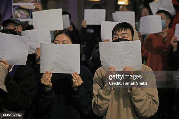 Protesters hold white signs in protest of the Chinese Government on November 28, 2022 in Melbourne, Australia. Urumqi officials said 10 people were...