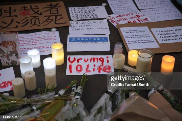 Sign surrounded by candles with "Urumqi 10 life" on November 28, 2022 in Melbourne, Australia. Urumqi officials said 10 people were killed in a fire...