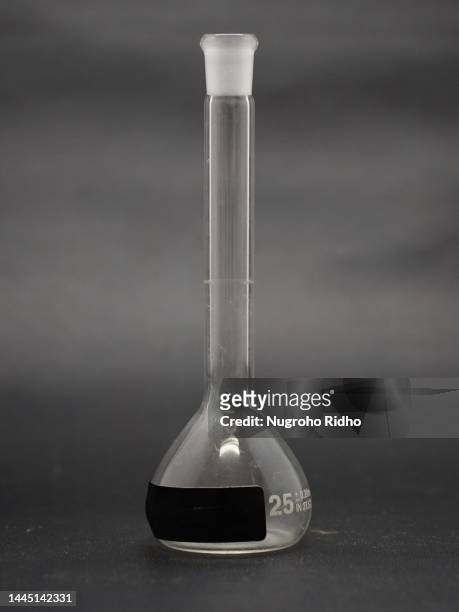 25 ml volumetric flask on black background - laboratory glassware stock-fotos und bilder