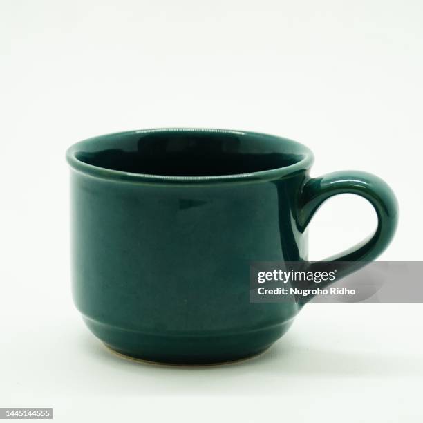 green ceramic tea cup on white background - マグカップ ストックフォトと画像