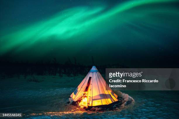 aurora borealis on a tent in the snow - camp site stock-fotos und bilder