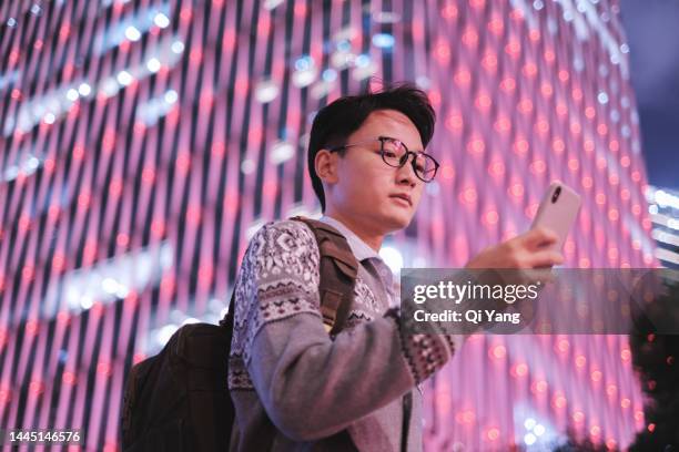 young asian business man using smartphone in financial district of shanghai - big data center stock pictures, royalty-free photos & images