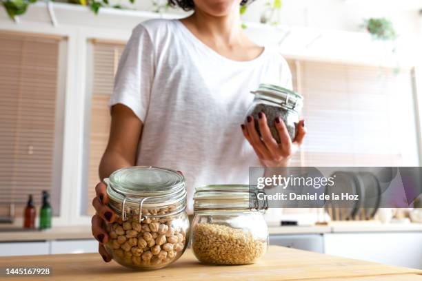 unrecognizable woman organising pantry. legumes and cereals in glass containers. shopping in bulk. zero waste. - kitchen pantry bildbanksfoton och bilder