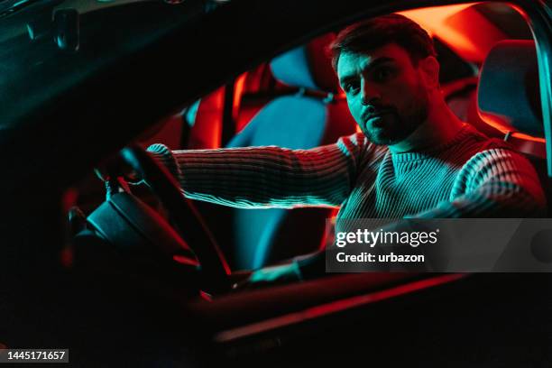 young man in the car at night - road rage stock pictures, royalty-free photos & images