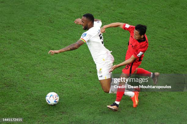 Jordan Ayew of Ghana is tackled by Wooyeong Jeong of Korea Republic during the FIFA World Cup Qatar 2022 Group H match between Korea Republic and...