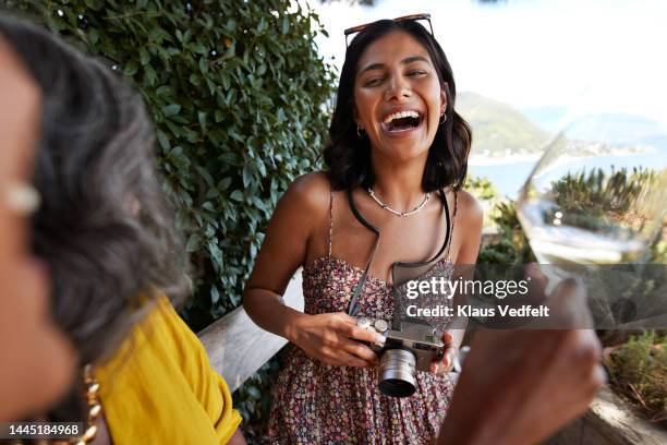 young woman with camera laughing by friends - brown hair drink wine stock pictures, royalty-free photos & images