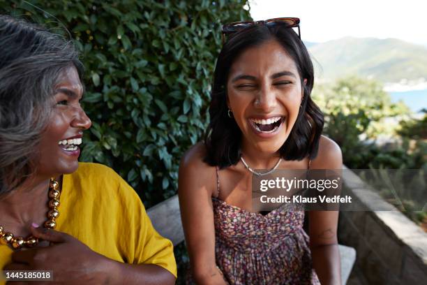 cheerful female friends laughing together - sourire à pleines dents photos et images de collection