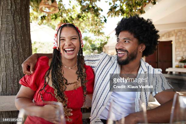 happy man sitting with arm around woman - wear red day - fotografias e filmes do acervo