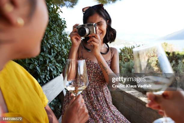 young woman photographing female friends - digitale camera stockfoto's en -beelden