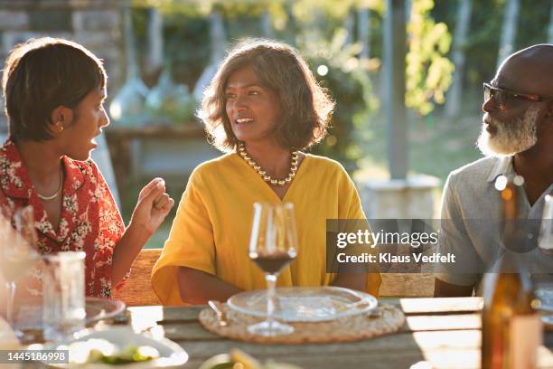 young woman talking to couple in party - asian woman black shirt stock pictures, royalty-free photos & images