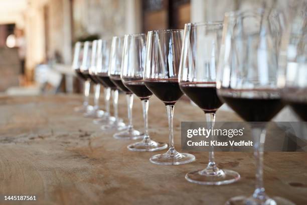 red wine glasses arranged in row on table - wijn proeven stockfoto's en -beelden