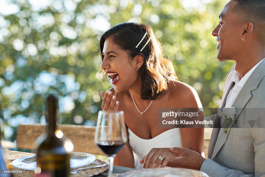Young bride laughing by groom in party