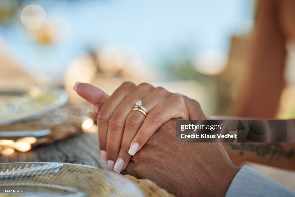 Bride with wedding ring holding hand of groom