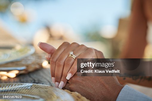 Bride with wedding ring holding hand of groom Bride with wedding ring holding hand of groom