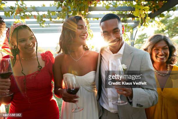 happy married couple and friends with wineglasses - wedding guests stockfoto's en -beelden