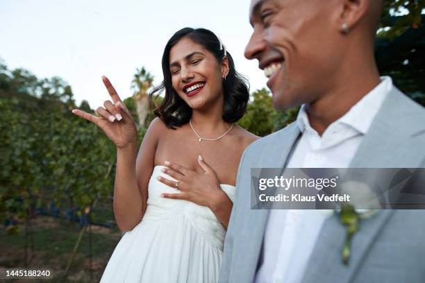 happy bride gesturing horn sign by groom - 新婚夫婦 個照片及圖片檔