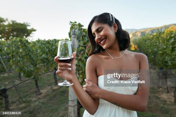 smiling bride holding wineglass in vineyard - rural scene wedding stock pictures, royalty-free photos & images