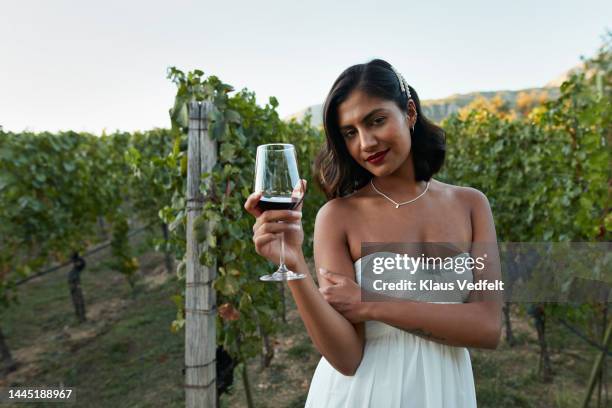 young bride with wineglass standing in vineyard - strapless dress stock pictures, royalty-free photos & images