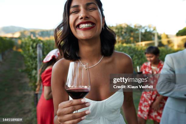 happy young bride holding wineglass at vineyard - happy face glasses stockfoto's en -beelden