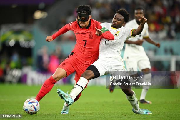 Heungmin Son of Korea Republic is tackled by Tariq Lamptey of Ghana during the FIFA World Cup Qatar 2022 Group H match between Korea Republic and...