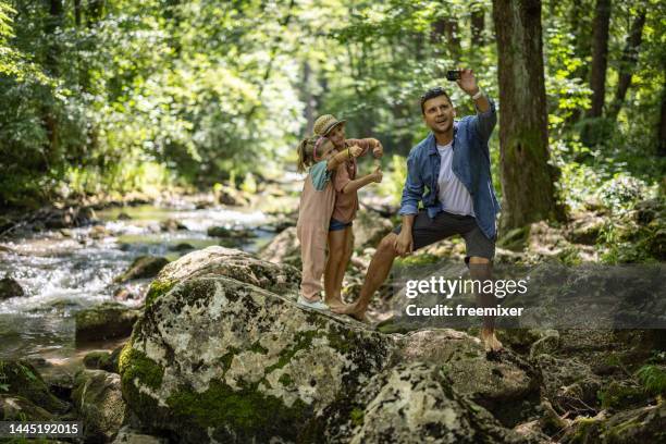 glücklicher vater und kinder beim selfie im wald - bachlauf stock-fotos und bilder