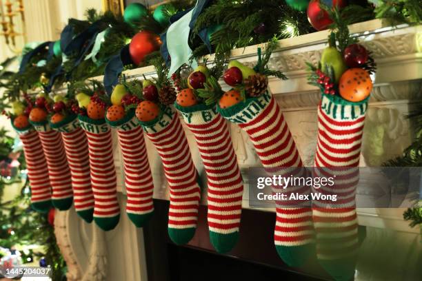 The traditional Biden family stockings are hung from the fireplace mantel in the State Dining Room of the White House during a press preview of the...