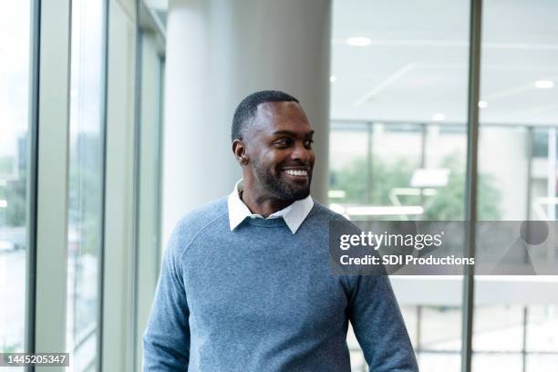 pharmacy technician smiling at his peers - medisch vertegenwoordiger stockfoto's en -beelden