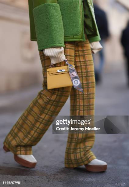 Karin Teigl is seen wearing Hermès yellow leather mini Kelly, Baum & Pferdgarten green leather jacket, Lumina beige cropped turtleneck sweater,...