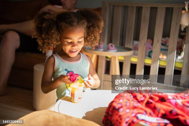 happy girl playing with pink clay - black girl ponytail stock pictures, royalty-free photos & images