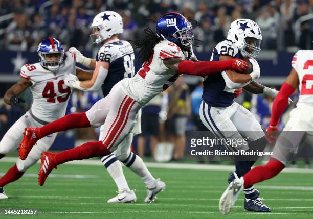 Jaylon Smith of the New York Giants tackles Tony Pollard of the Dallas Cowboys at AT&T Stadium on November 24, 2022 in Arlington, Texas.