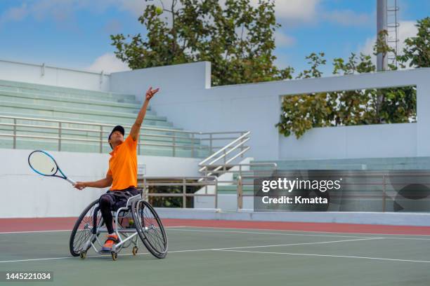 wheelchair tennis player preparing to serve during a wheelchair tennis match. - table tennis table photos et images de collection
