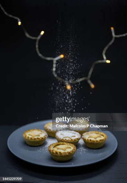 christmas mince pies with lights and icing (powdered) sugar snow - sweet food stock pictures, royalty-free photos & images