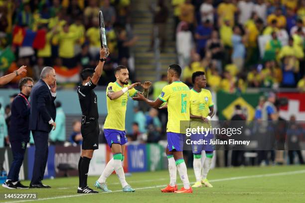 Alex Sandro of Brazil interacts with Alex Telles of Brazil as they are substituted during the FIFA World Cup Qatar 2022 Group G match between Brazil...