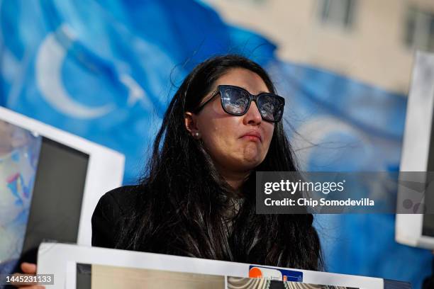 Woman weeps as the East Turkistan Government in Exile national anthem is played during a rally of Uyghur and other Turkic people outside the State...