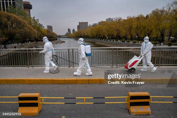 Epidemic control workers wear PPE to protect against the spread of COVID-19 as they disinfect an area on the Liangma River, a popular area for local...