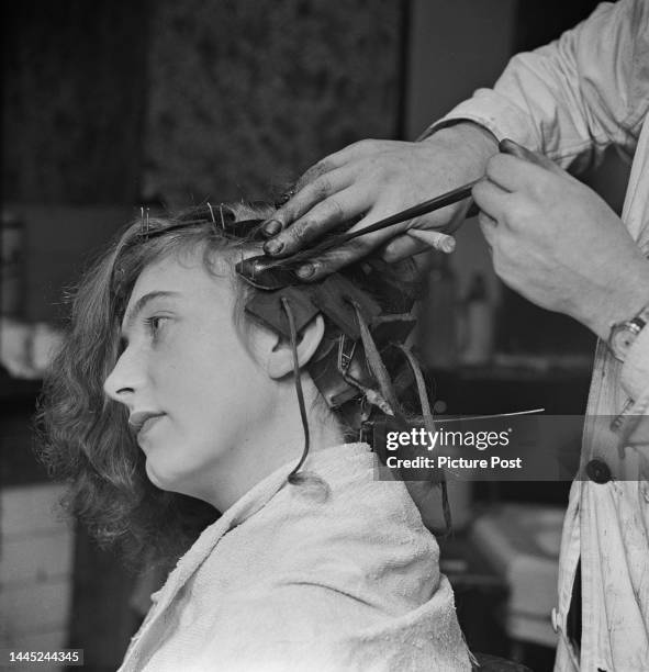 Woman having a cold perm at the salon of Scottish hairdresser Jack Farrell in Elephant and Castle, London, January 1945. The perm was developed by...