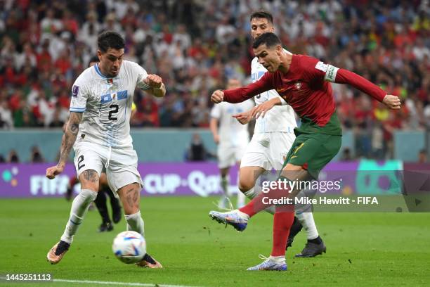 Cristiano Ronaldo of Portugal shoots while Jose Maria Gimenez of Uruguay attempts to block during the FIFA World Cup Qatar 2022 Group H match between...