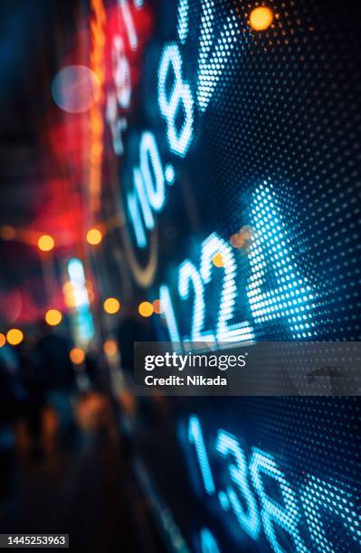 ausstellung von börsenkursen mit stadtszene reflektieren auf glas - dow jones industrial average stock-fotos und bilder