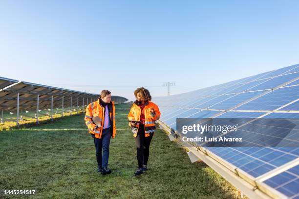engineers working at solar power plant - nachhaltiges wirtschaften stock-fotos und bilder