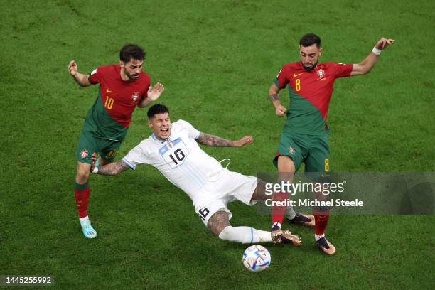 Mathias Olivera of Uruguay controls the ball against Bernardo Silva and Bruno Fernandes of Portugal during the FIFA World Cup Qatar 2022 Group H...