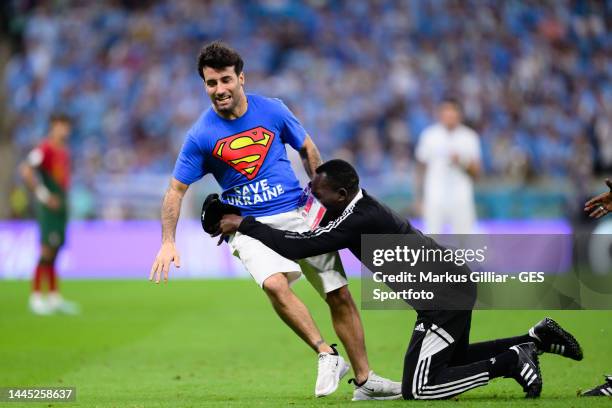 Streaker with message safe ukraine catched by security man during the FIFA World Cup Qatar 2022 Group H match between Portugal and Uruguay at Lusail...