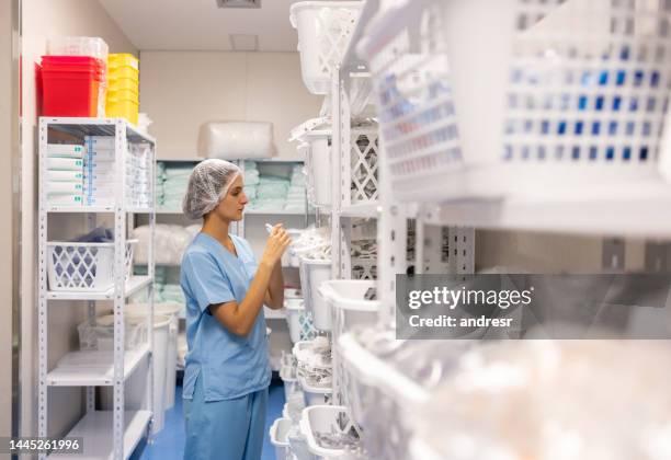 nurse taking medical supplies from the storage room at the hospital - medische artikelen stockfoto's en -beelden