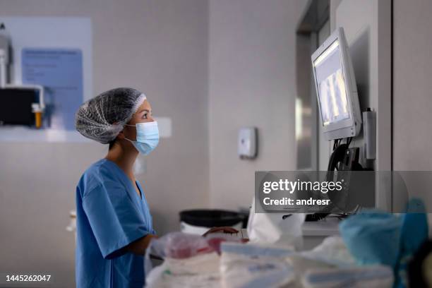 médico trabajando en el hospital y mirando una radiografía - tecnología sanitaria fotografías e imágenes de stock