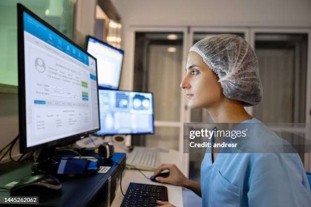 radiologe im kontrollraum, der einen medizinischen scan durchführt - medical technology stock-fotos und bilder