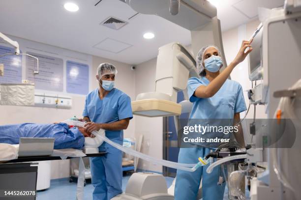 médicos hablando de un procedimiento médico en la sala de hemodinámica - sistema-cardiopulmonar-humano fotografías e imágenes de stock
